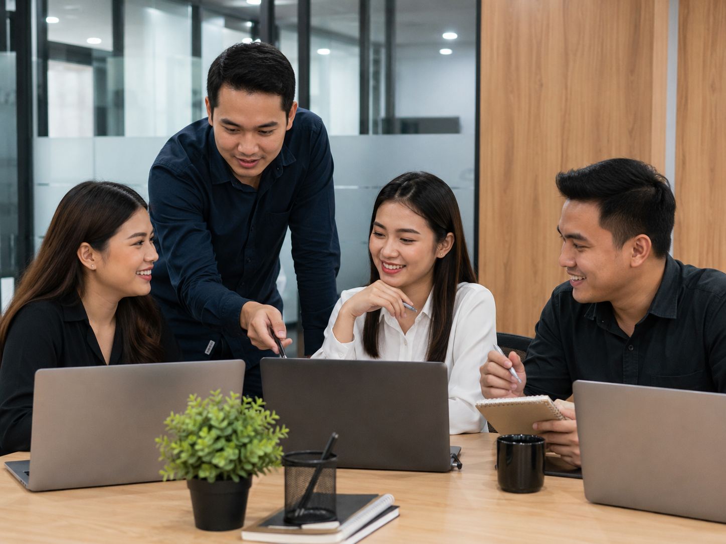 Filipino team collaborating around laptops